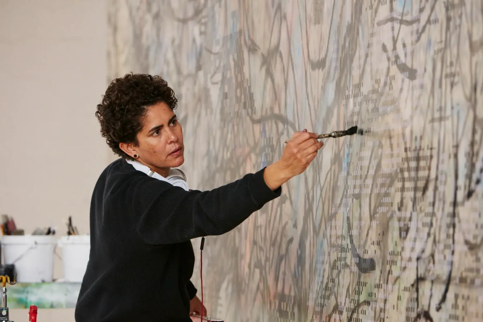 Julie Mehretu travaillant sur « HOWL, eon (I, II) » à l’église St. Thomas the Apostle à Harlem, en 2017. Courtesy de l'artiste, Marian Goodman Gallery et White Cube © Julie Mehretu. Photo : Tom Powel Imaging.